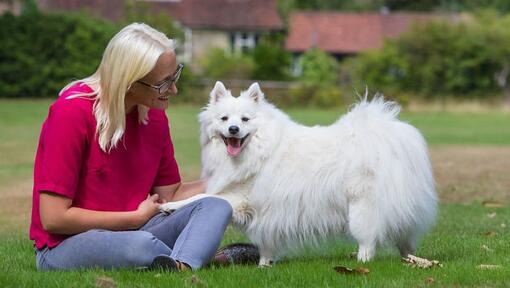 Mulher sentada do lado de fora com cachorro