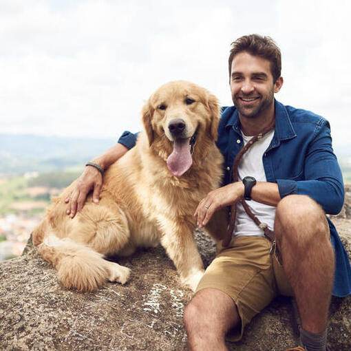 Homem com golden retriever na rocha